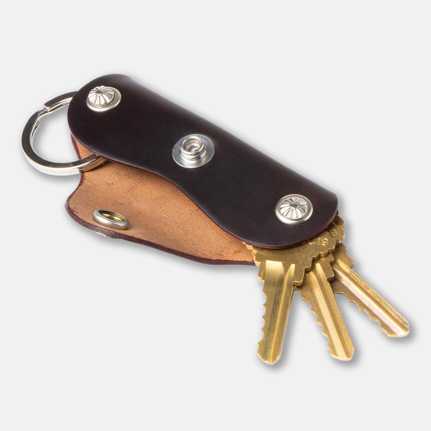 Leather keychain with brass keys on a light gray background