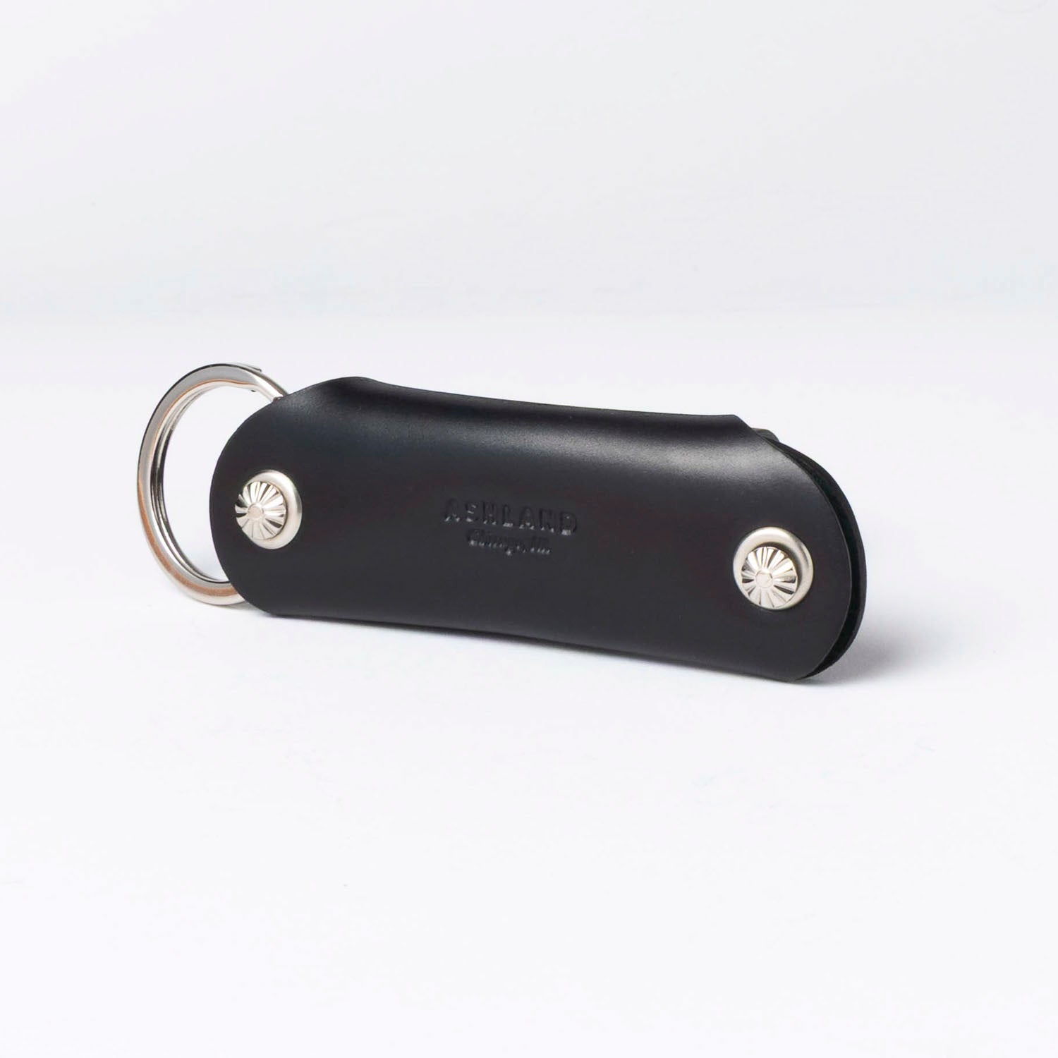 Black leather keychain with silver accents on a white background