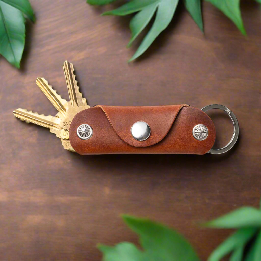 Brown leather key organizer with keys on a wood background