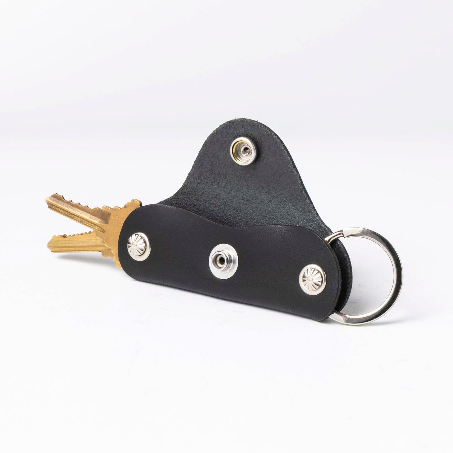 Black leather key holder with keys on a white background