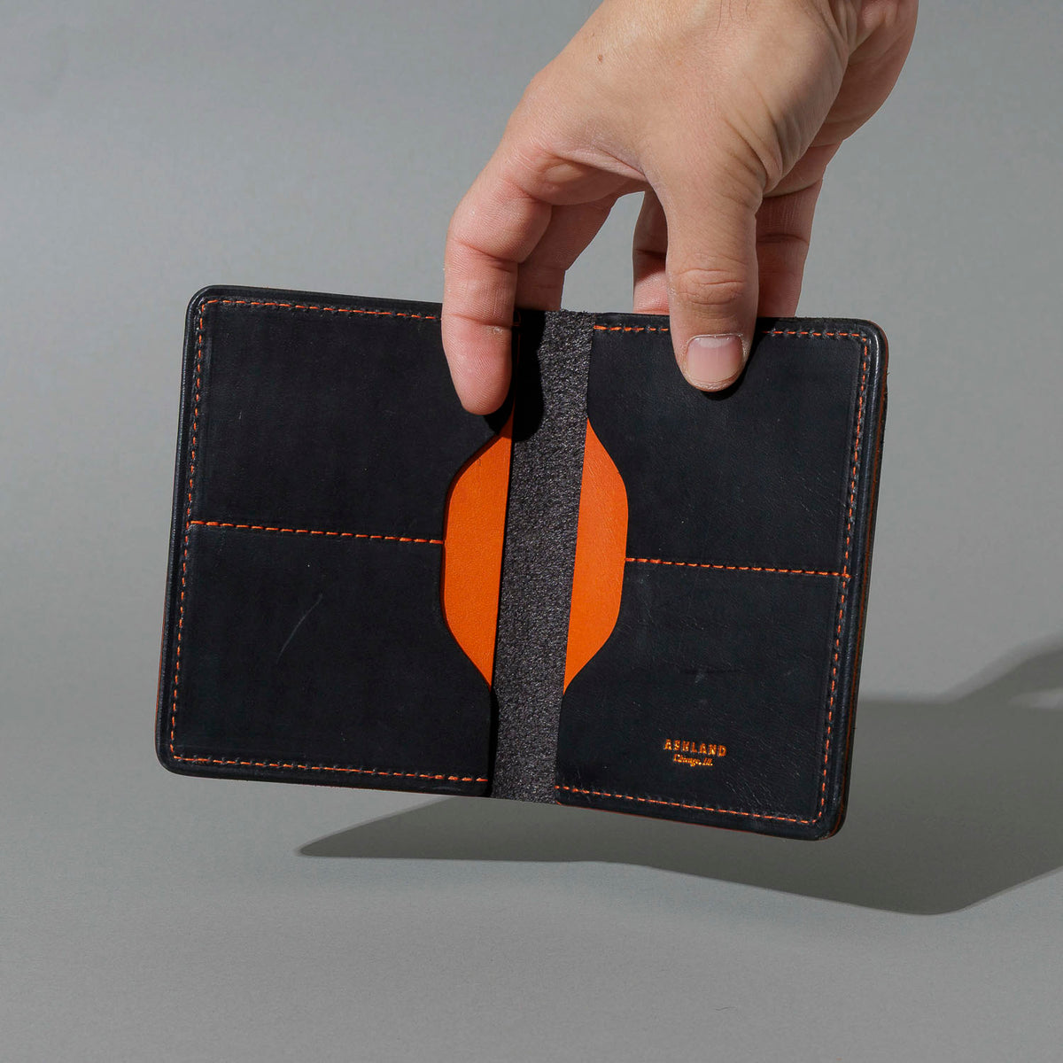 B-Grade One-Off Fat Herbie in Black Dublin & Orange Latigo, Two Hidden Card Slots, held open in hand
