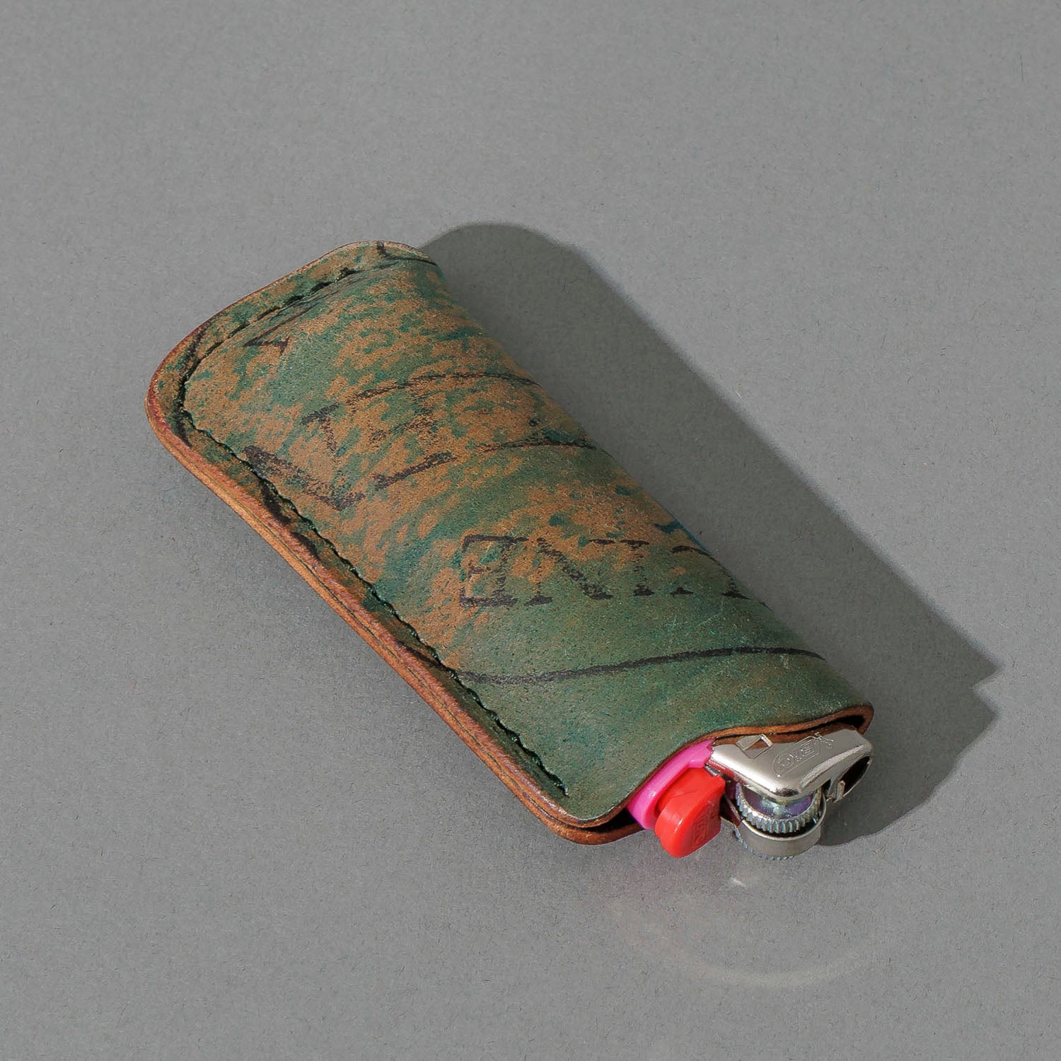 One-Off BIC Lighter and Sheath in Reverse Blue Shell Cordovan, angled view lying flat