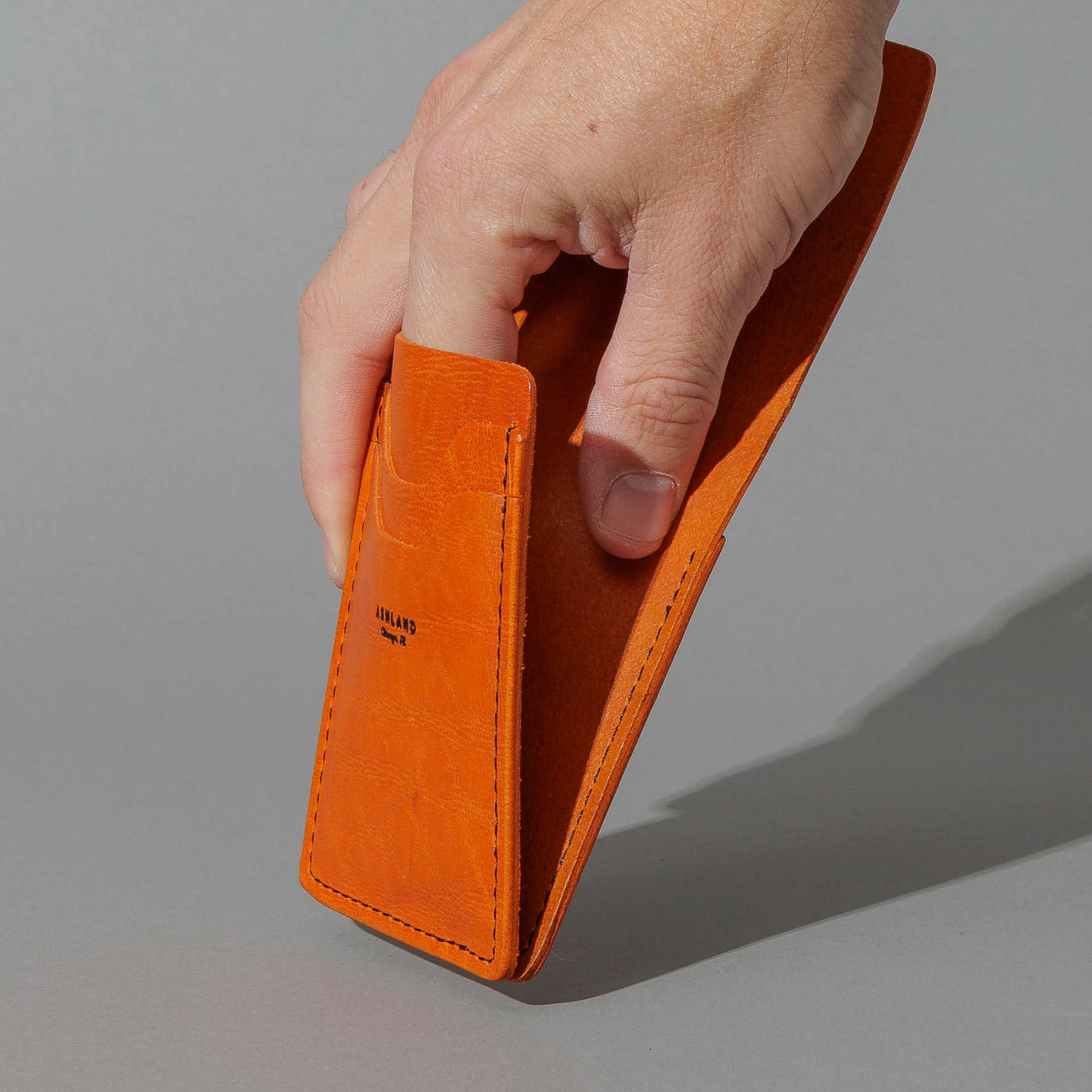 One-Off Lucky Wallet in Epic Orange Latigo, held in hand, shot 2