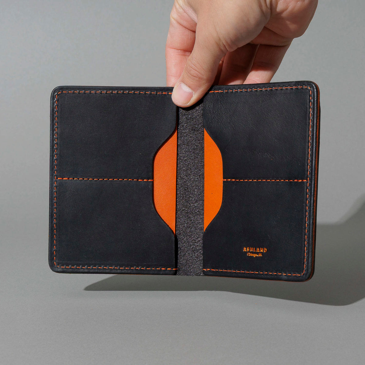 One-Off Fat Herbie in Black Dublin with Orange Accents, Two Hidden Card Slots, held open in hand