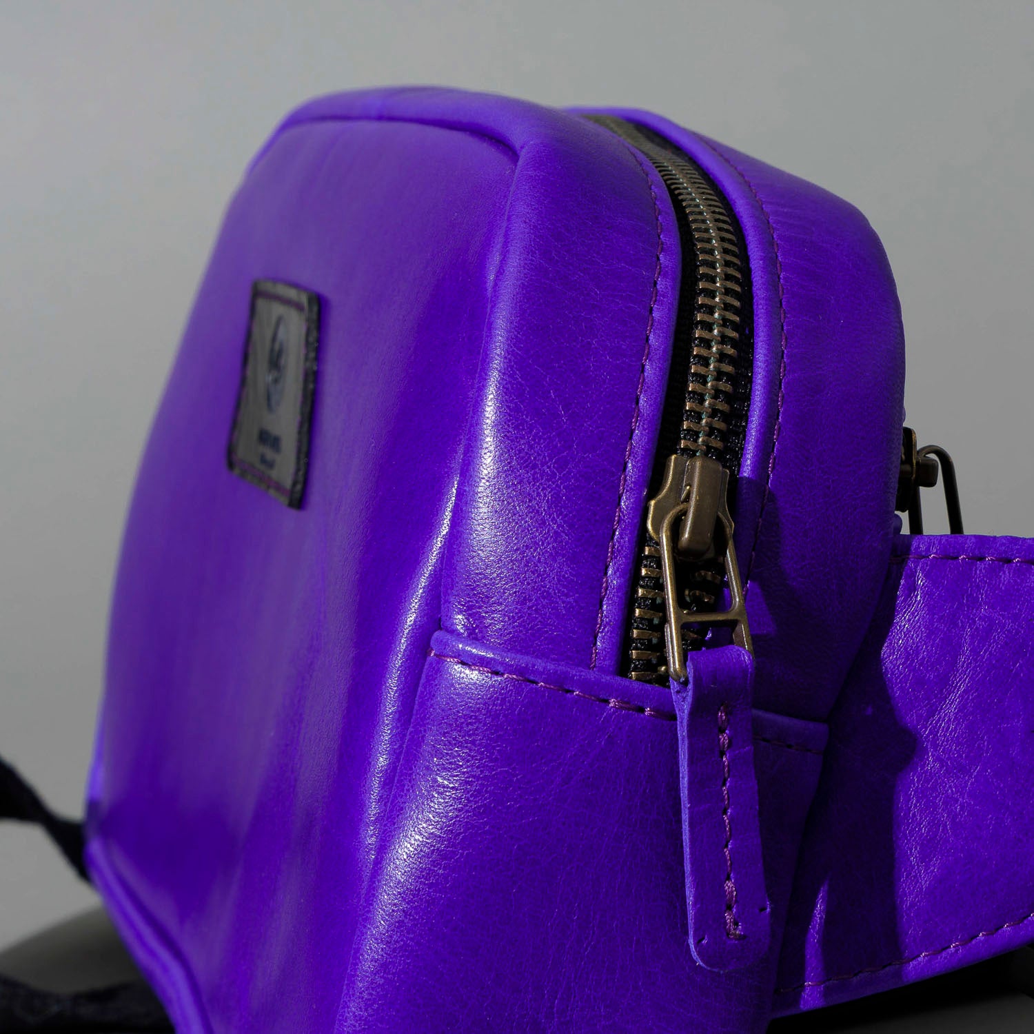 One-Off Sling Bag in Violet Latigo, angled view lying flat, shot 1