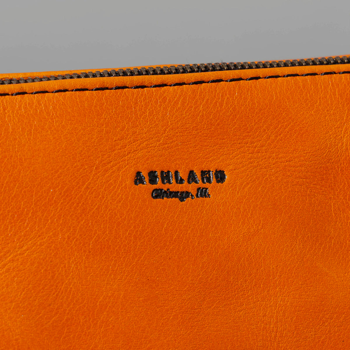 One-Off Zipper Pouch in Orange Latigo, Bat Embroidery, close-up of the logo patch