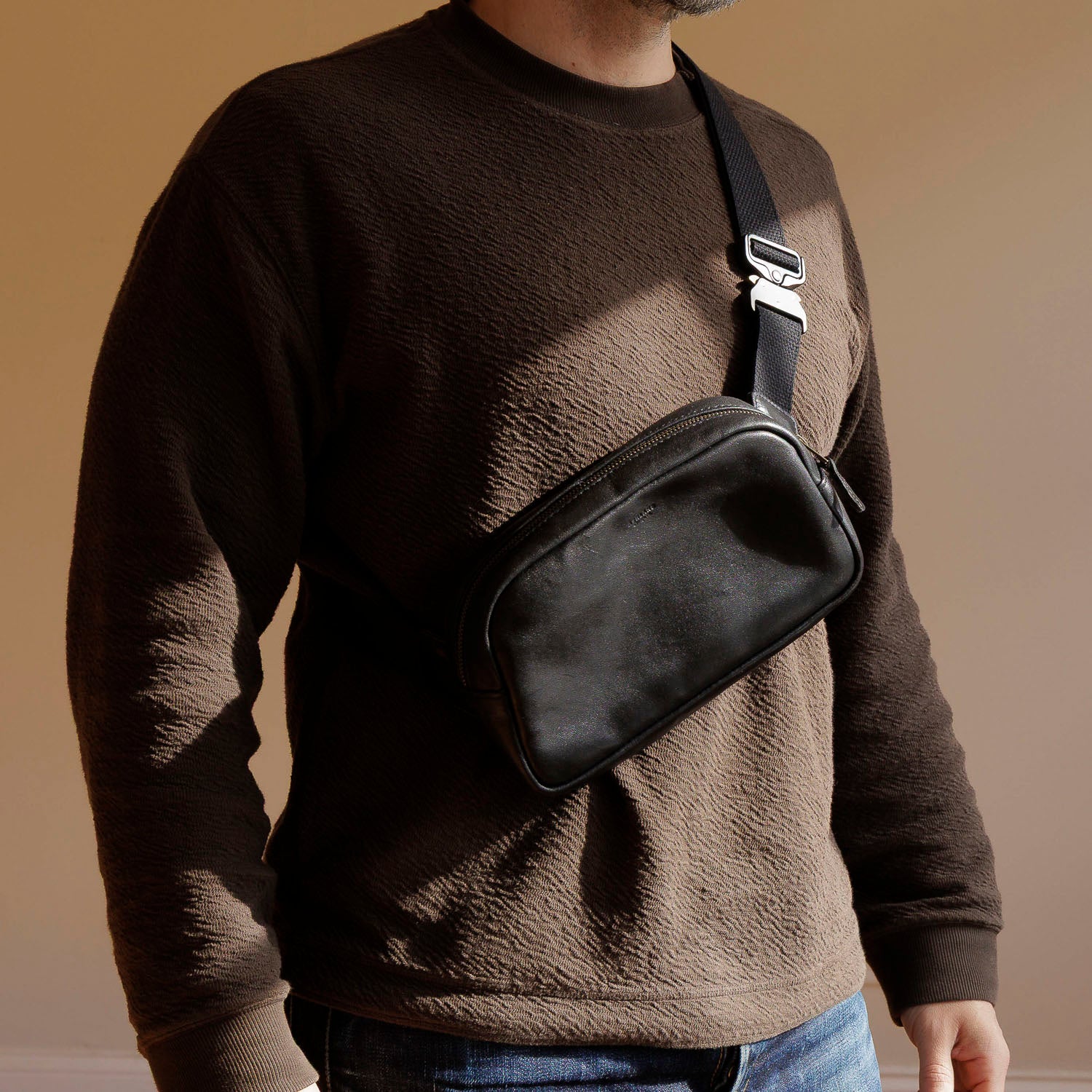 Sling Bag in Black Aspen Horsehide, worn crossbody by a model, shot 1