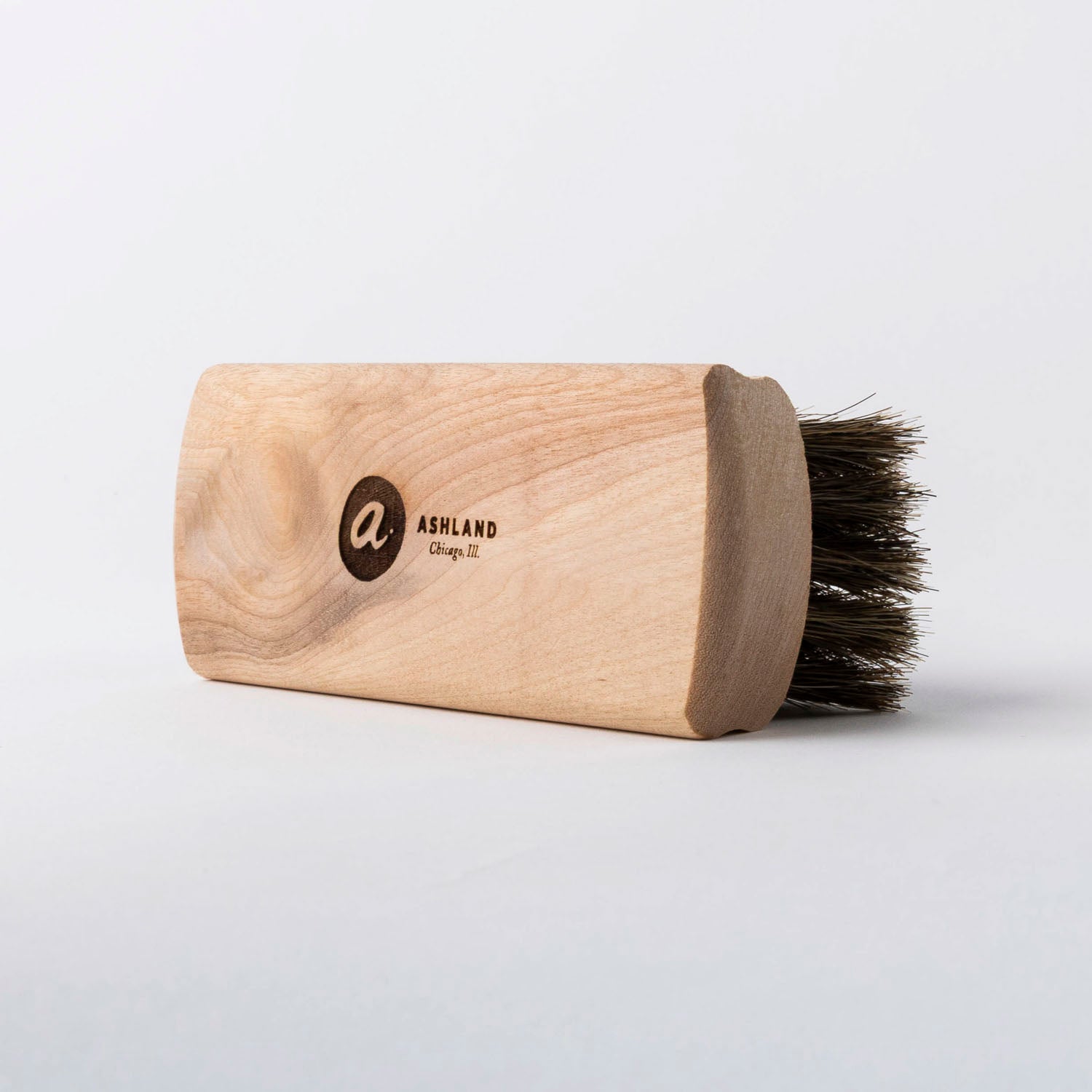 Wooden brush with bristles on a light gray background
