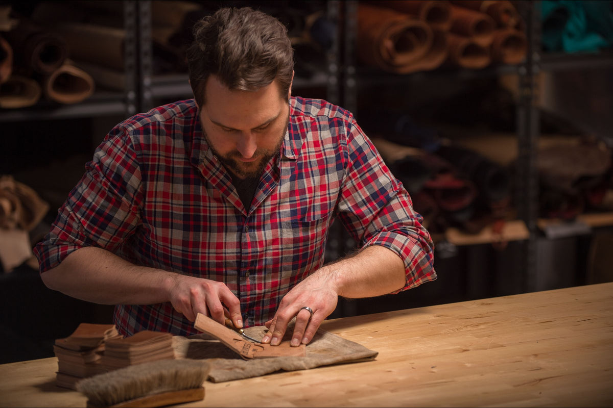 Ashland craftsman cutting Horween® leather at the bench in our Chicago workshop