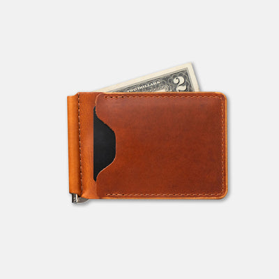 Brown leather money clip with a two-dollar bill sticking out on a white background