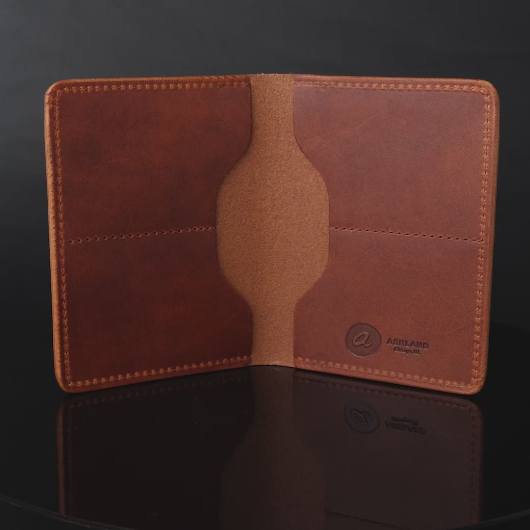 Brown leather wallet spinning on reflective table