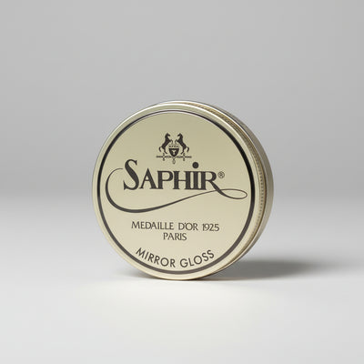 Saphir Mirror Gloss tin on a gray background
