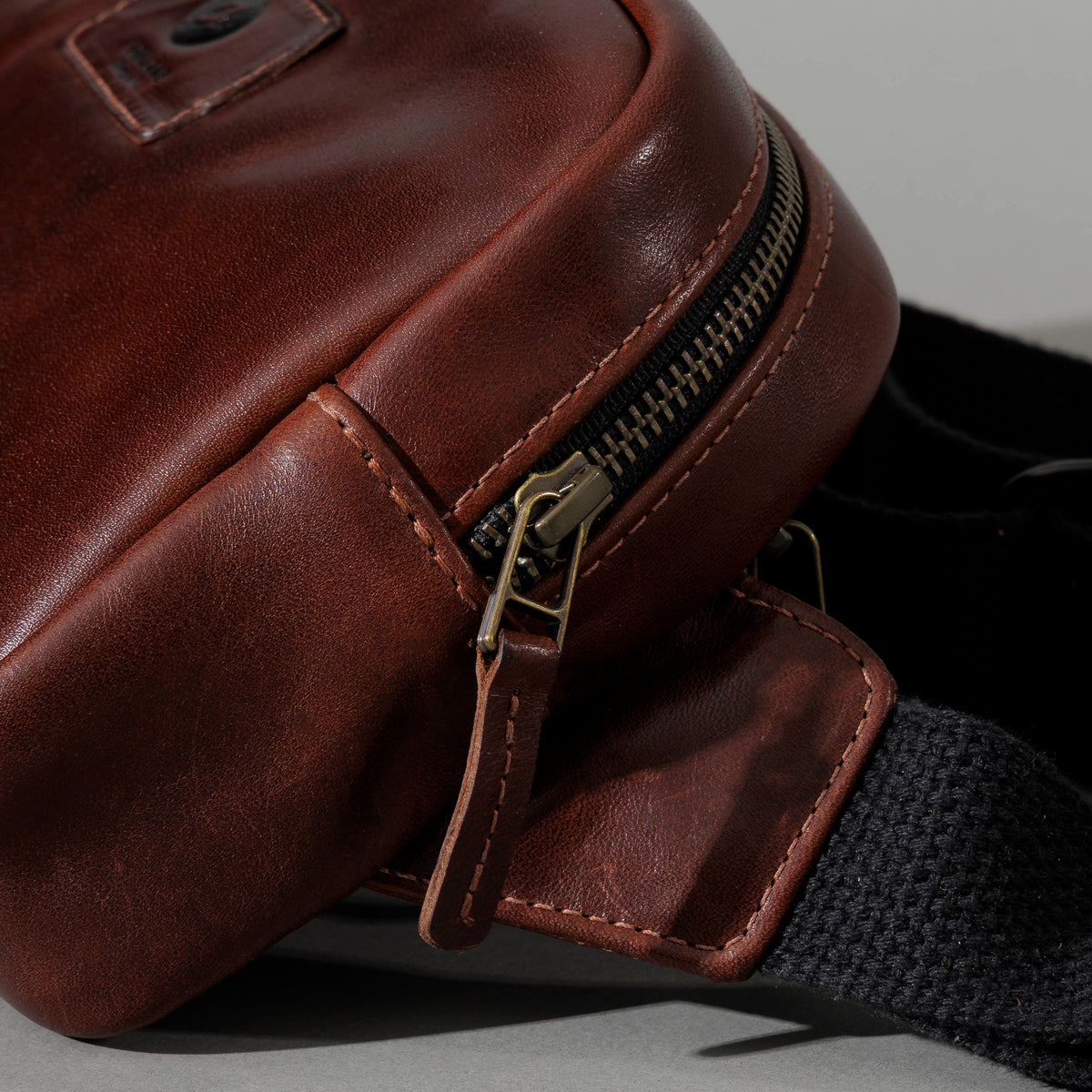 Sling Bag in Horween® Chromexcel® Brown Wooly horsehide, zipper end and strap tab close-up
