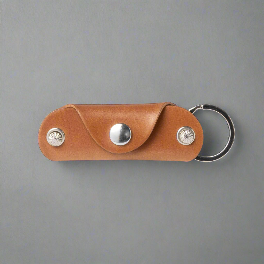 Brown leather keychain with metal accents on a white background