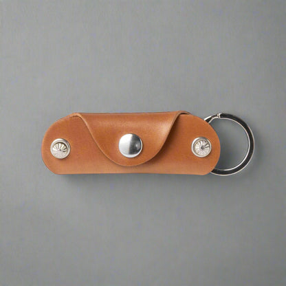 Brown leather keychain with metal accents on a white background