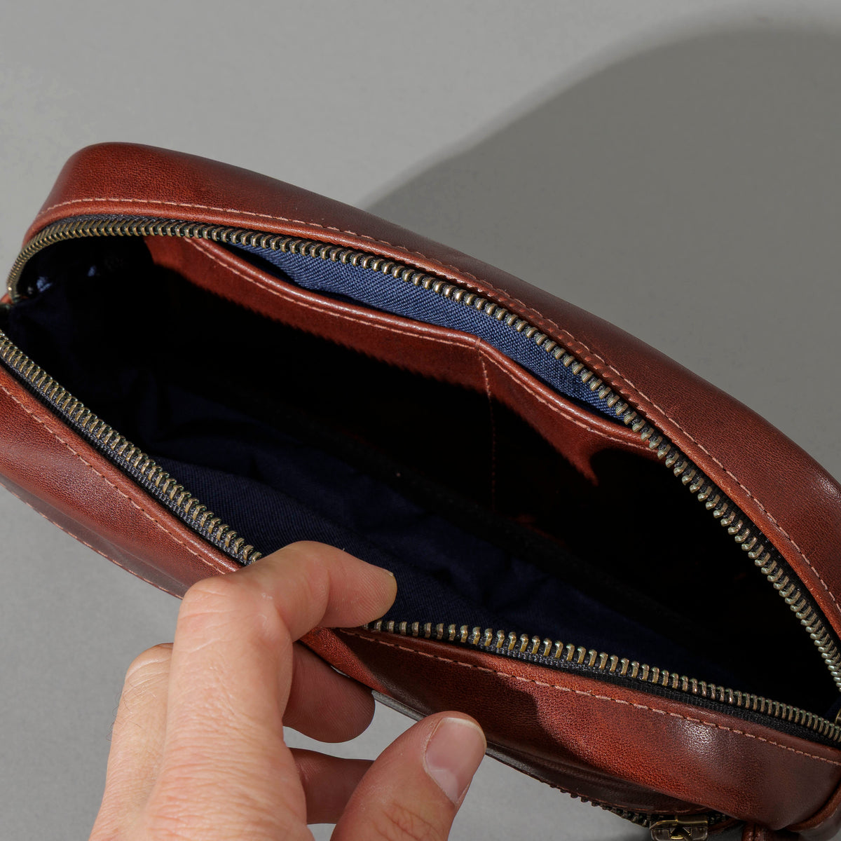 Sling Bag in Horween® Chromexcel® Brown Wooly horsehide, unzipped, showing the navy lining and pockets
