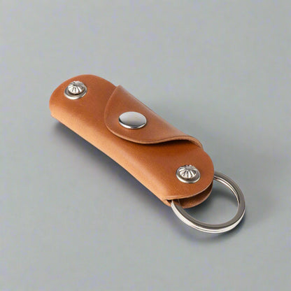 Brown leather key fob with metal rings on a white background