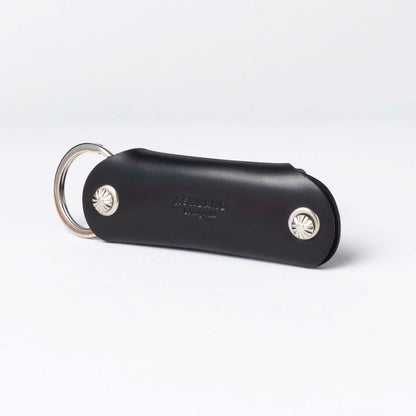 Black leather keychain with silver accents on a white background