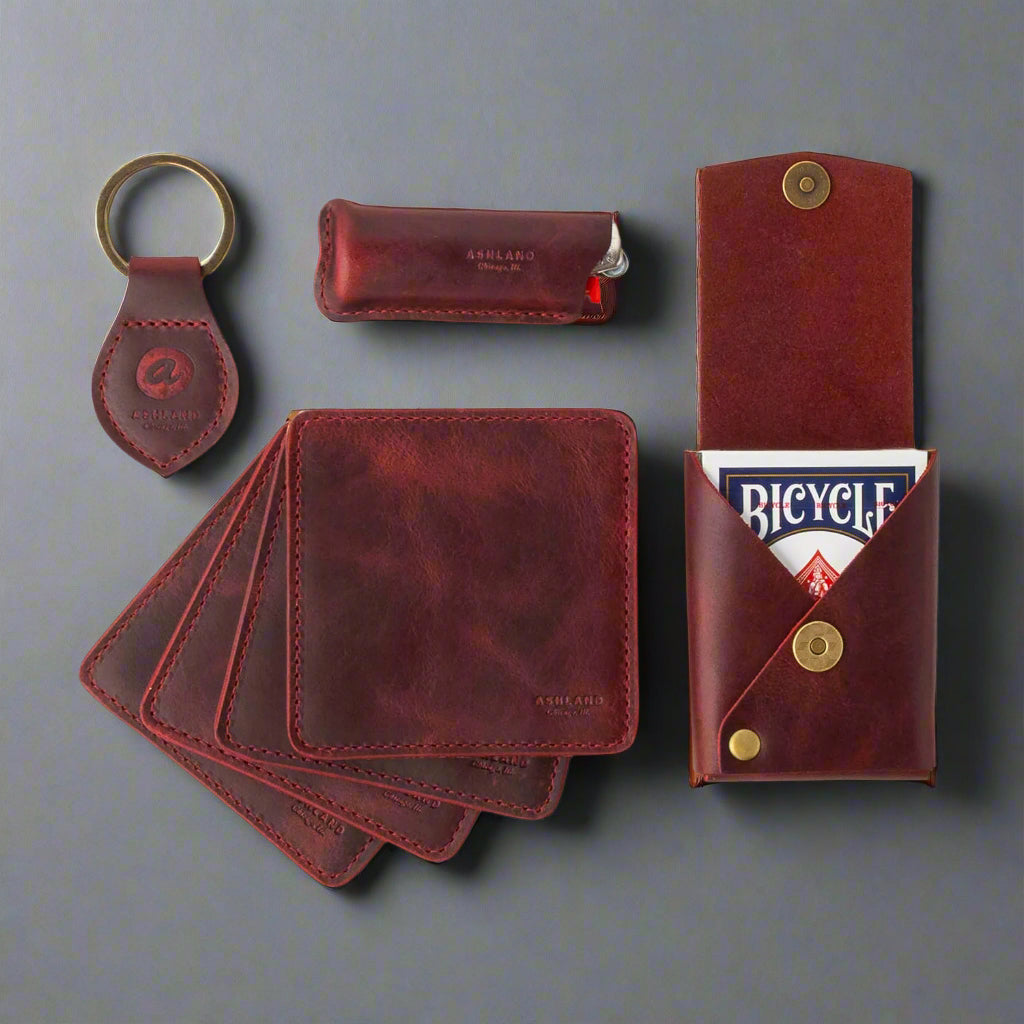 Set of red leather wallets, cardholders, and keychain on a white background