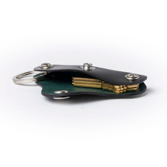 Black leather keychain with gold accents on a white background