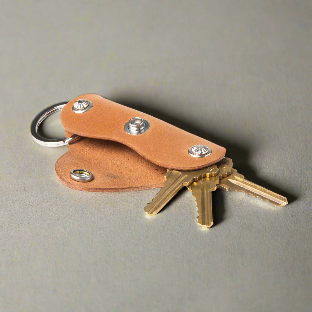 Brown leather key holder with keys on a white background