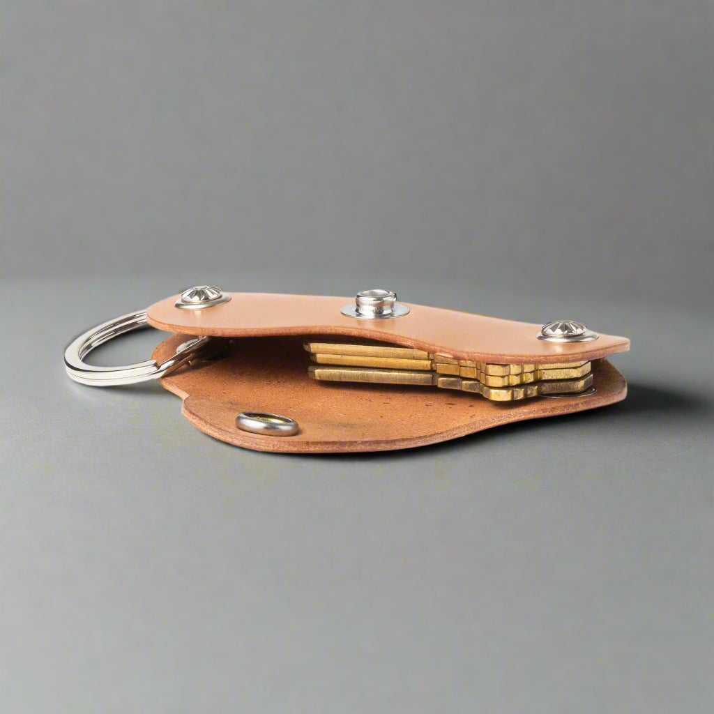 Brown leather keychain with brass components on a white background