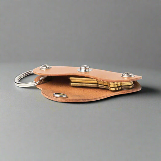 Brown leather keychain with brass components on a white background