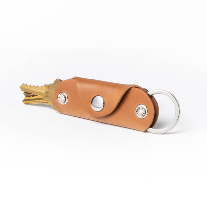 Brown leather case with gold tool and silver components on a white background