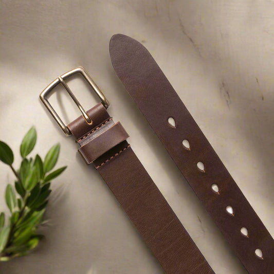 Brown leather belt with brass buckle on a white background