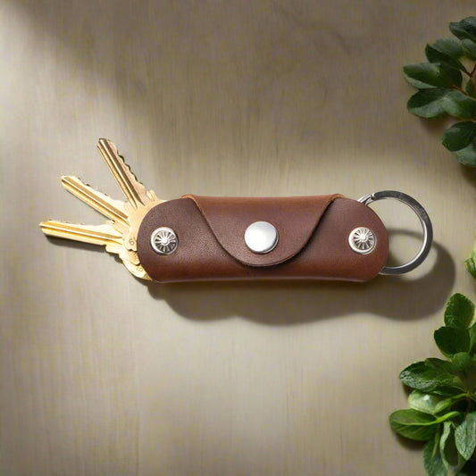 Brown leather key organizer with keys on a white background