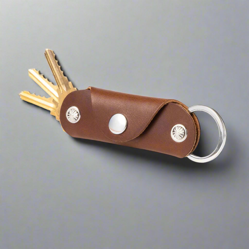 Brown leather key organizer with keys on a white background
