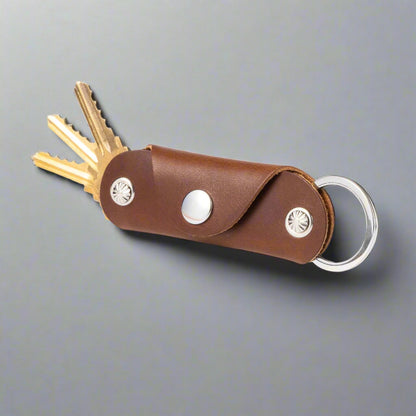 Brown leather key organizer with keys on a white background