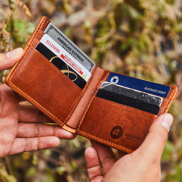 Ashland Leather Horween® leather bifold wallet held in hand outdoors