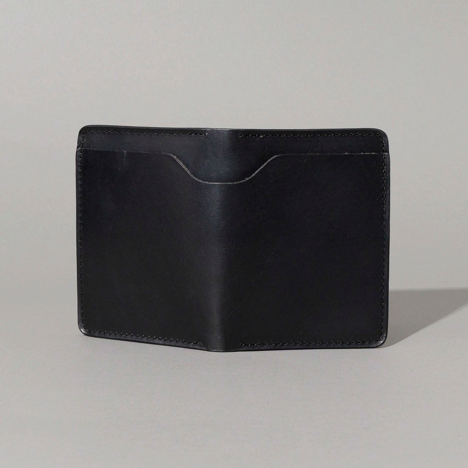 Front of the closed B-Grade Fat Herbie in black Horween® Dublin with a curved thumb notch above the front pocket