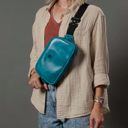 One-off Sling Bag in Horween® Teal Latigo leather, worn crossbody over a linen shirt