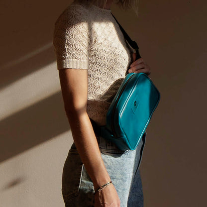 One-off Sling Bag in Horween® Teal Latigo leather, worn crossbody, front view in sunlight