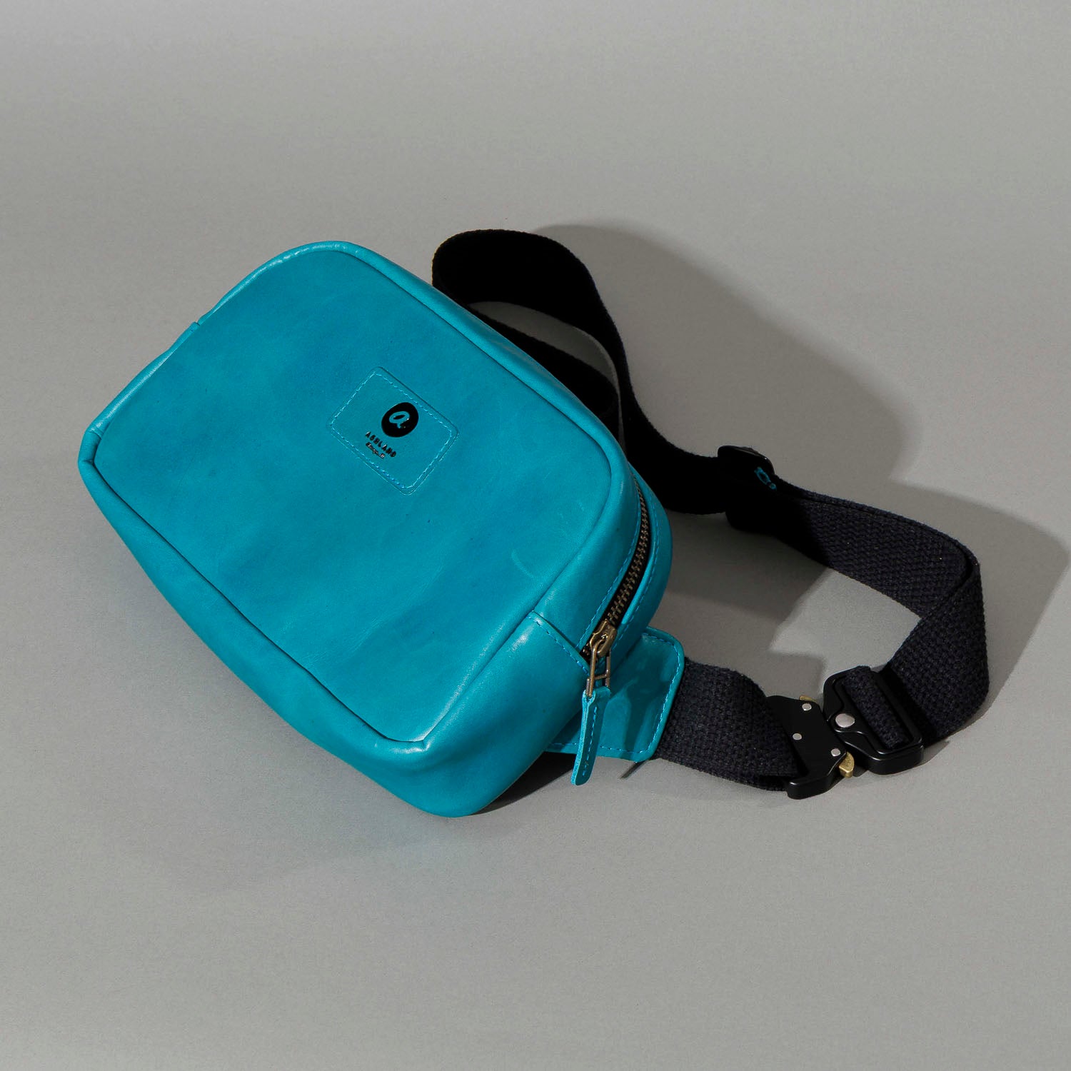 One-off Sling Bag in Horween® Teal Latigo leather, front three-quarter view with black webbing strap