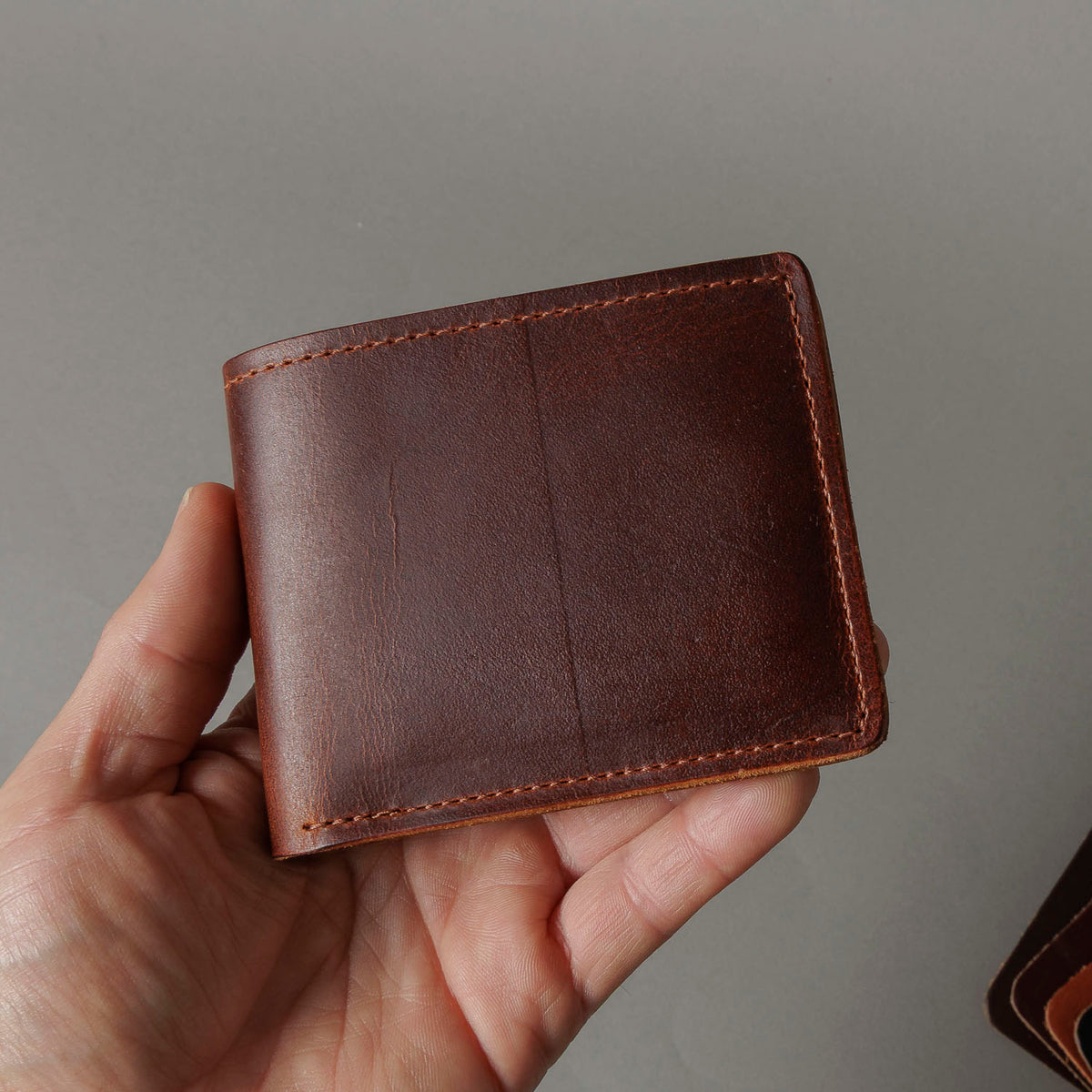 Ashland Leather Mystery Box, brown Horween® leather bifold wallet held in hand