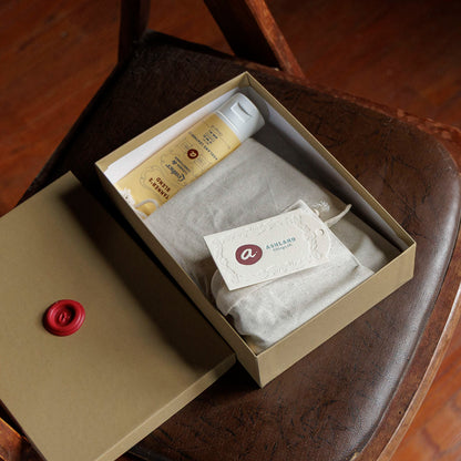 Ashland Leather Mystery Box with lid off, tissue wrapped pieces, leather care cream and Ashland tag