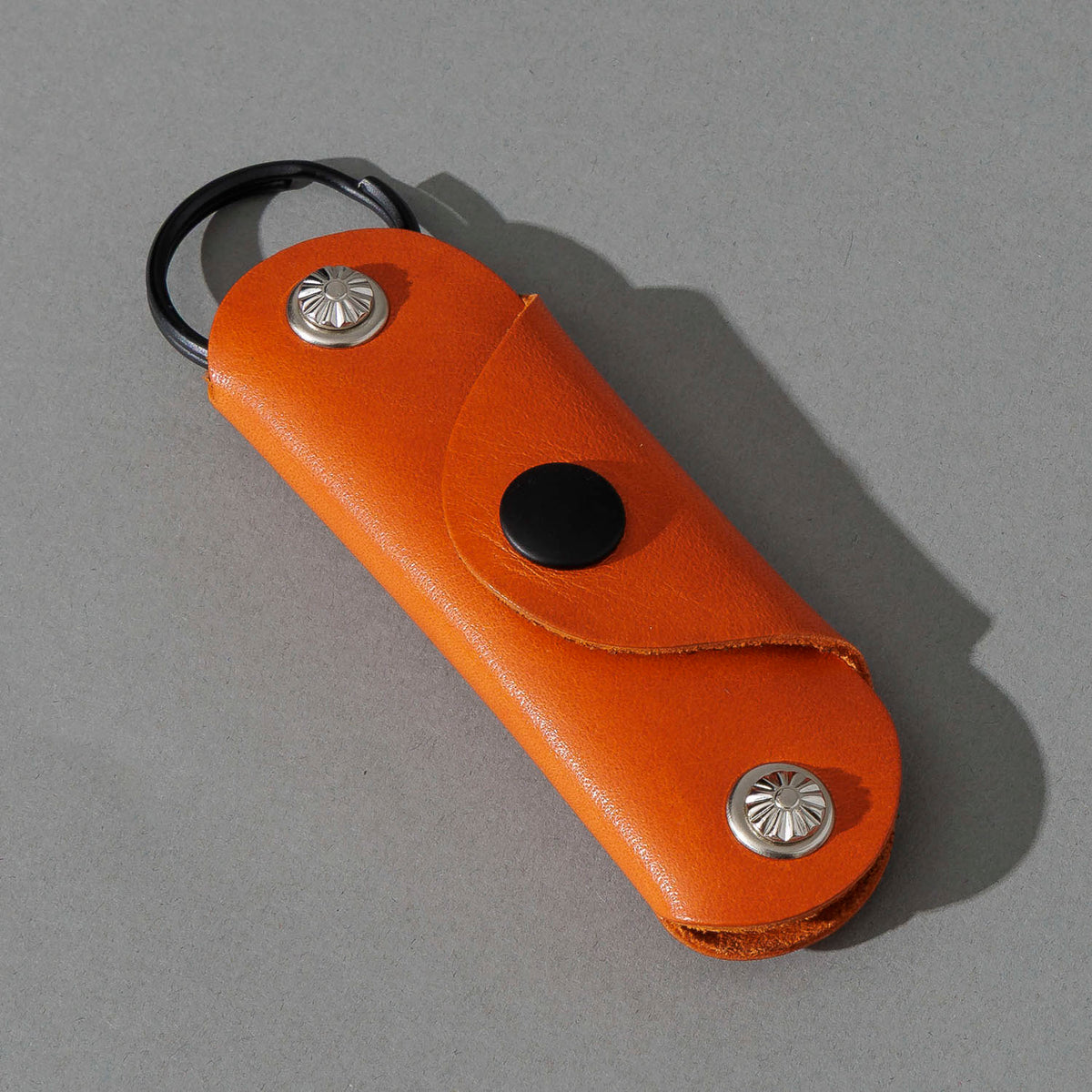 Vault Key Holder in Orange Latigo, angled view lying flat