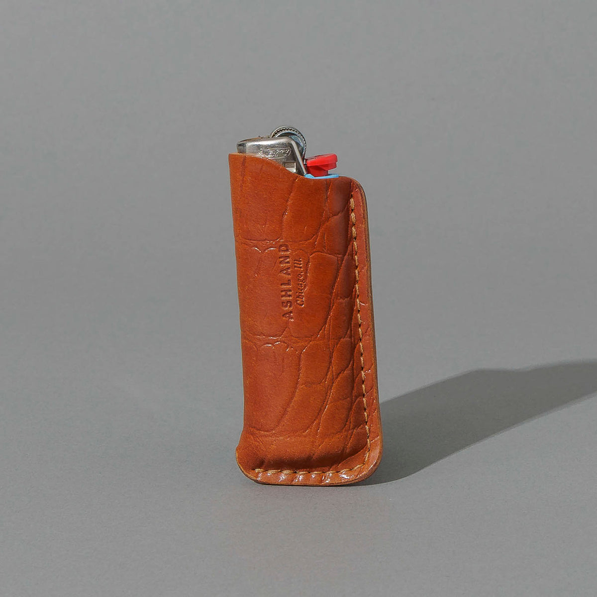 BIC Lighter and Sheath in Gator Amaretto Shell Cordovan, standing upright, side angle, shot 1