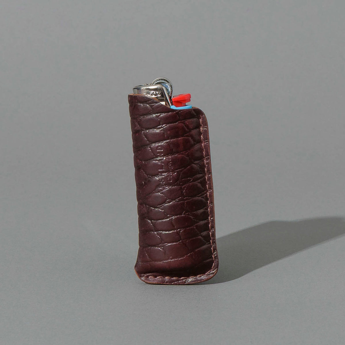 One-Off BIC Lighter and Sheath in Gator Color 8 Shell Cordovan, standing upright, side angle, shot 1
