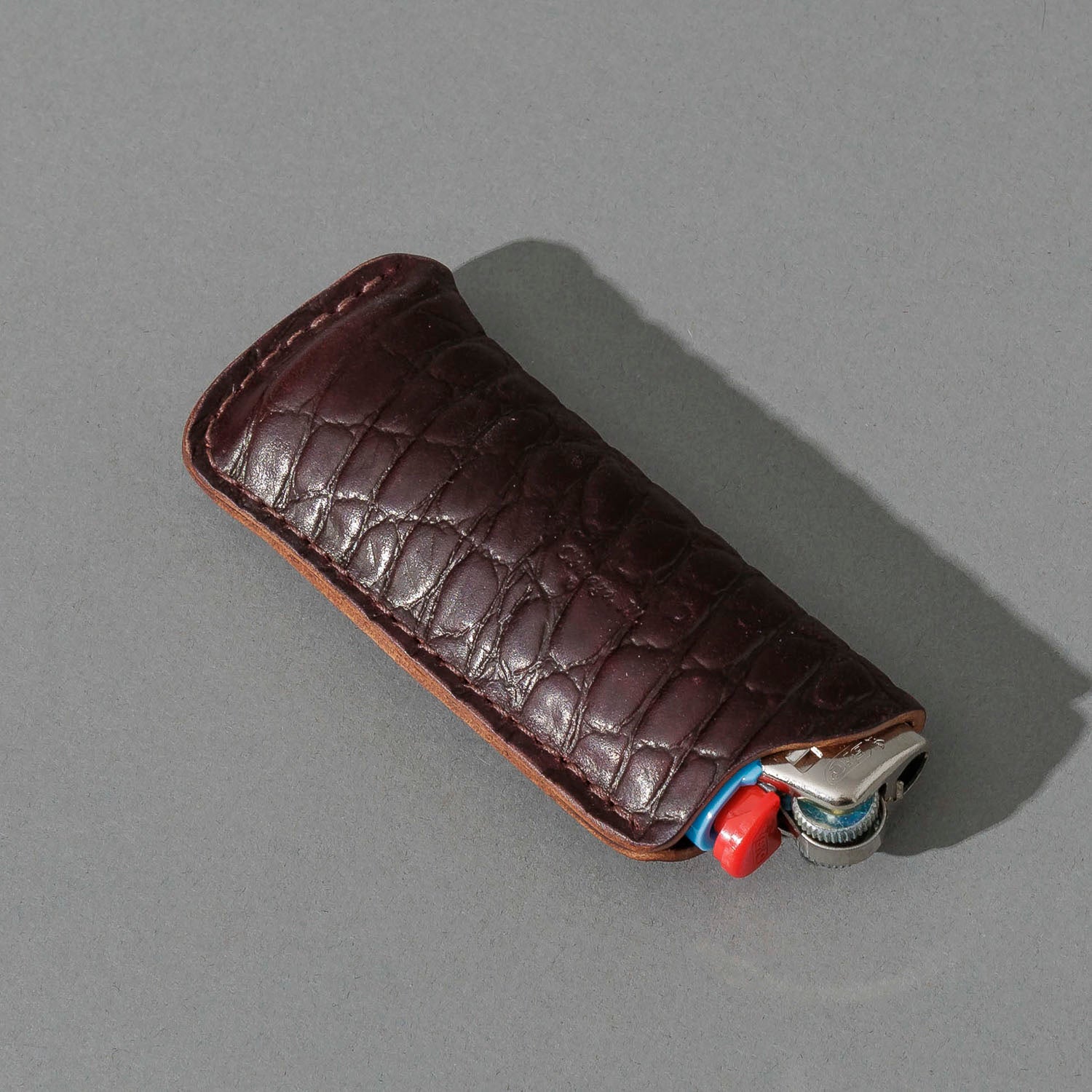 One-Off BIC Lighter and Sheath in Gator Color 8 Shell Cordovan, angled view lying flat