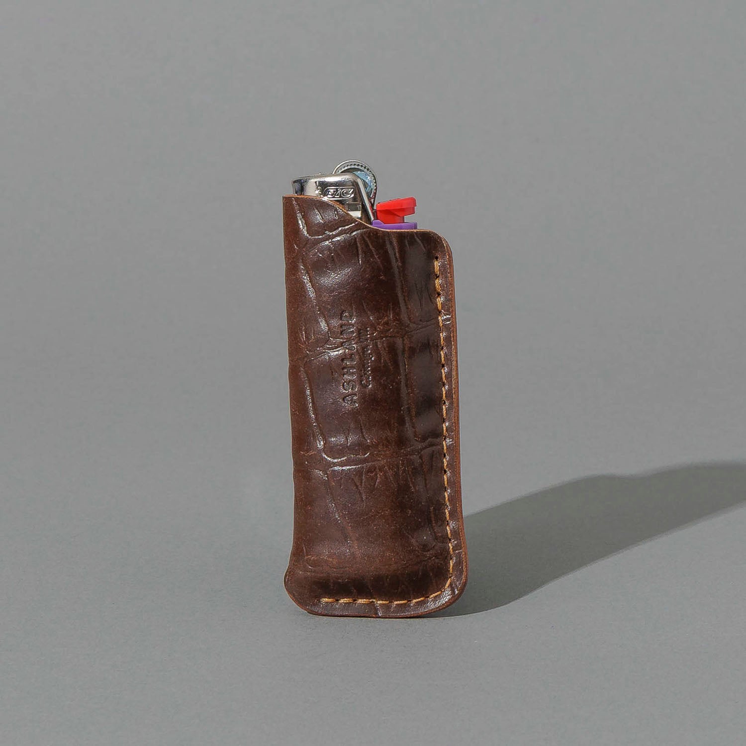 One-Off BIC Lighter and Sheath in Gator Cigar Shell Cordovan, standing upright, side angle, shot 1
