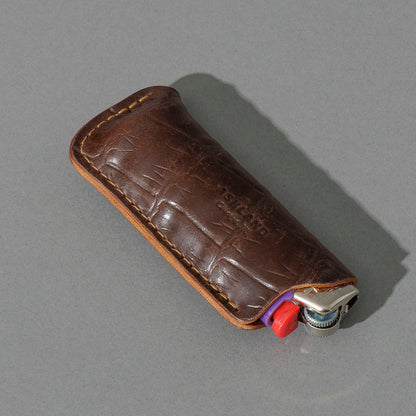 One-Off BIC Lighter and Sheath in Gator Cigar Shell Cordovan, angled view lying flat