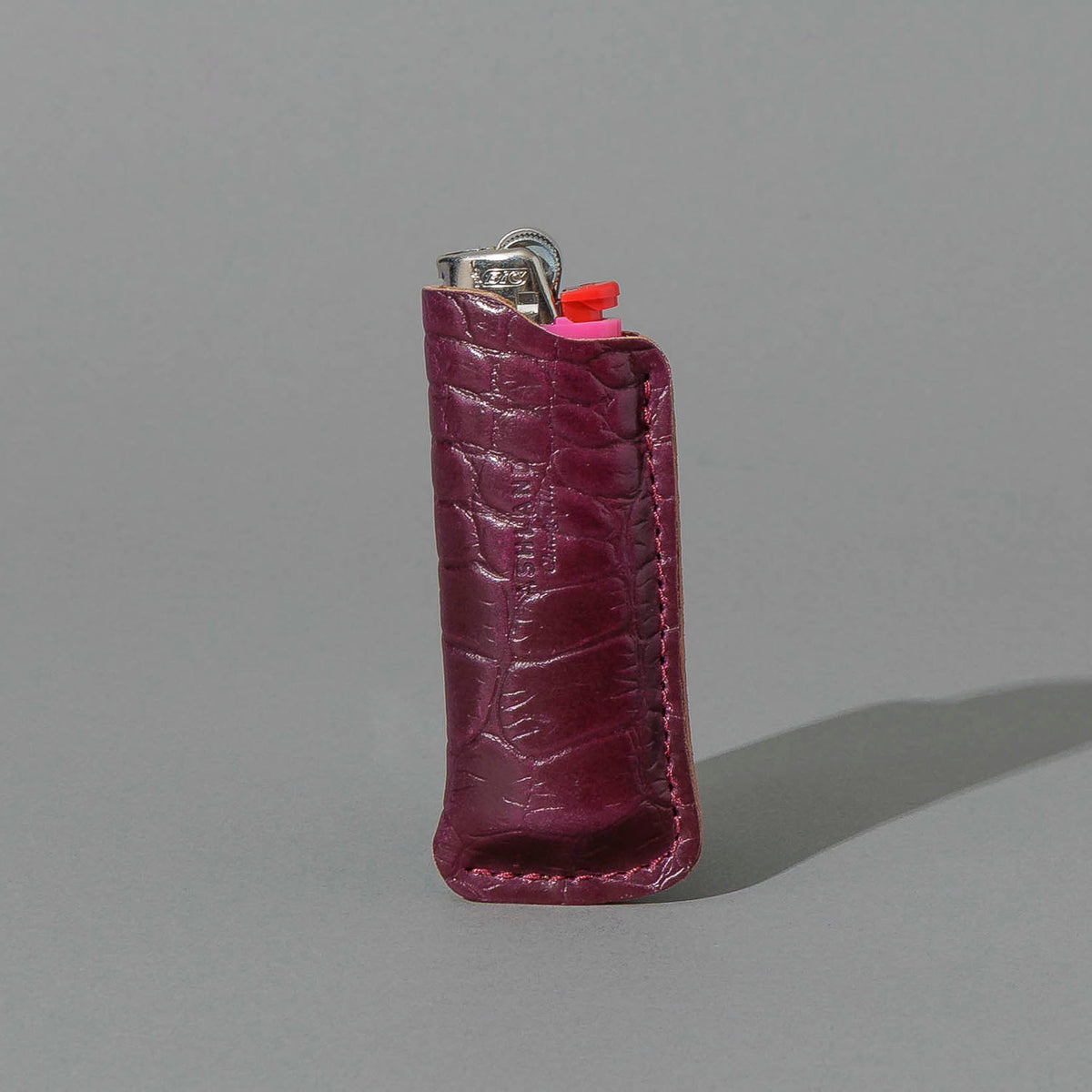 One-Off BIC Lighter and Sheath in Gator Ultraviolet Shell Cordovan, standing upright, side angle, shot 1