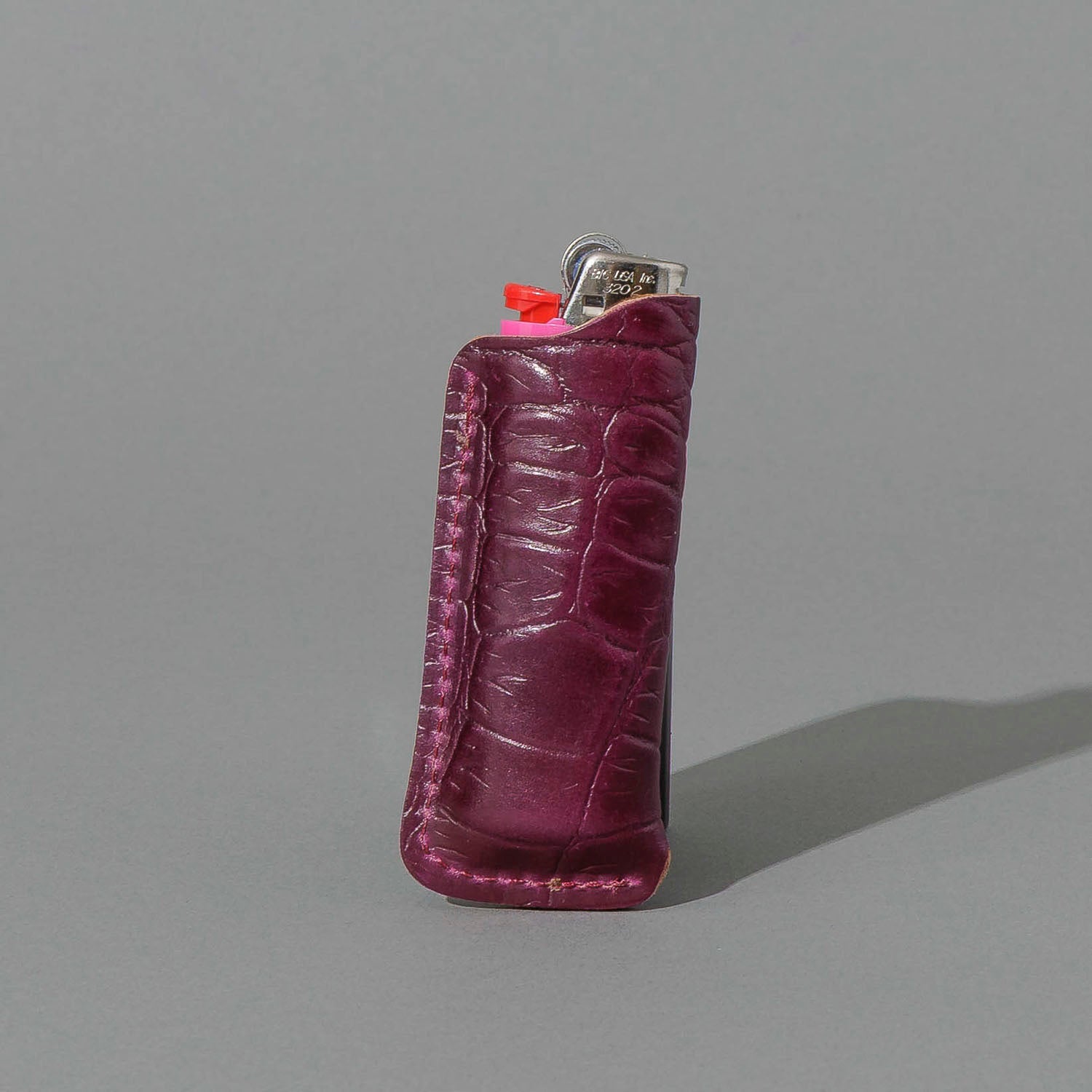 One-Off BIC Lighter and Sheath in Gator Ultraviolet Shell Cordovan, standing upright, side angle, shot 2