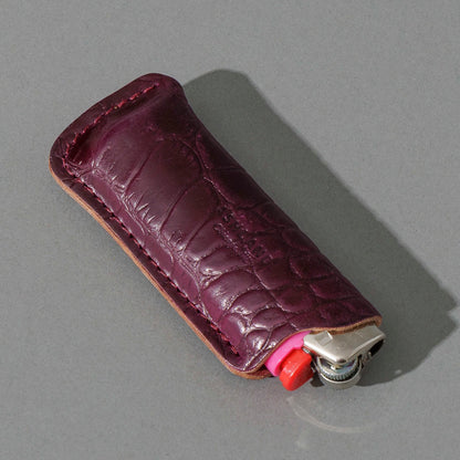 One-Off BIC Lighter and Sheath in Gator Ultraviolet Shell Cordovan, angled view lying flat
