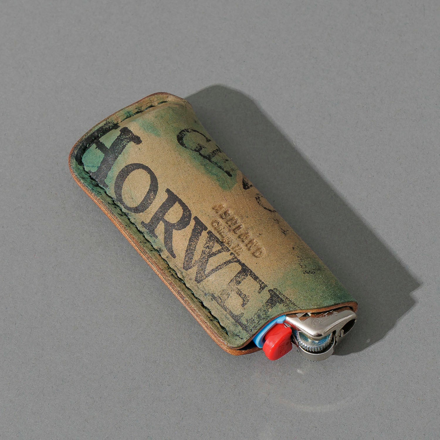 One-Off BIC Lighter and Sheath in Reverse Blue Shell Cordovan, angled view lying flat