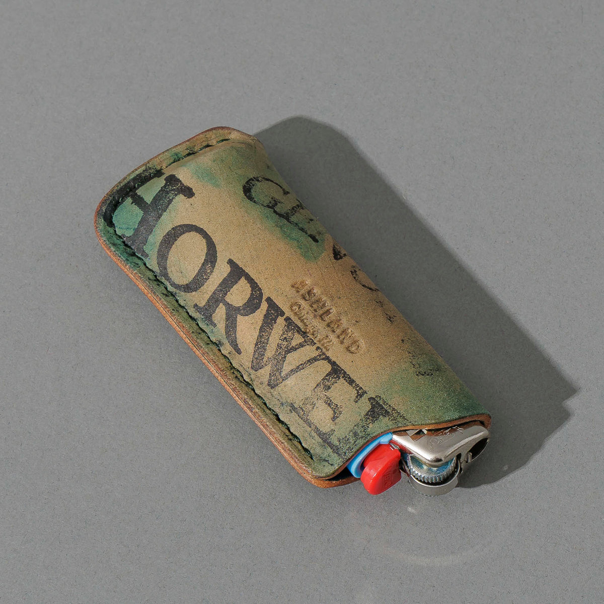 One-Off BIC Lighter and Sheath in Reverse Blue Shell Cordovan, angled view lying flat